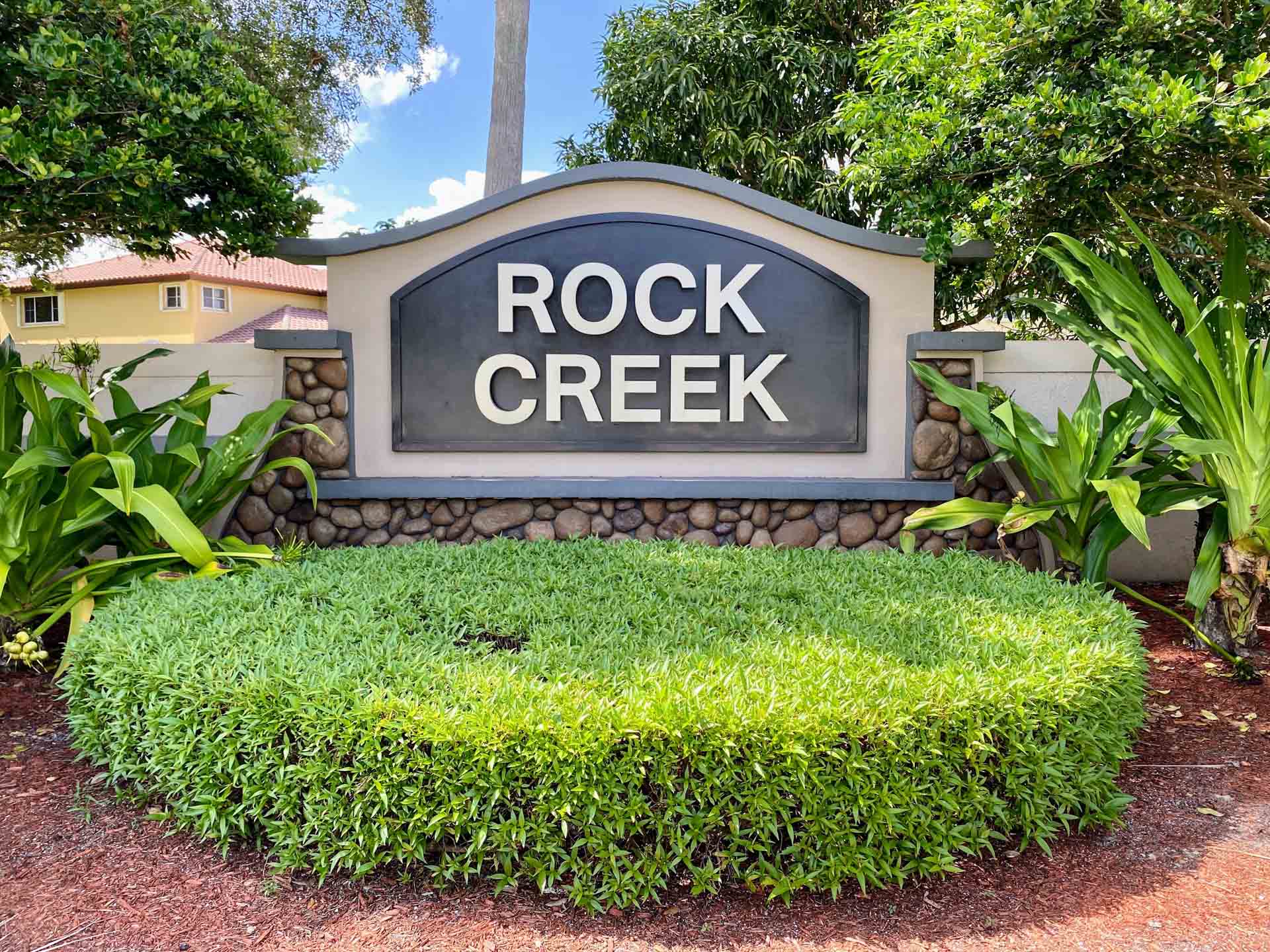 Panoramic aerial view of luxury lakefront homes in Rock Creek Cooper City, showcasing lush landscaping and winding waterways.