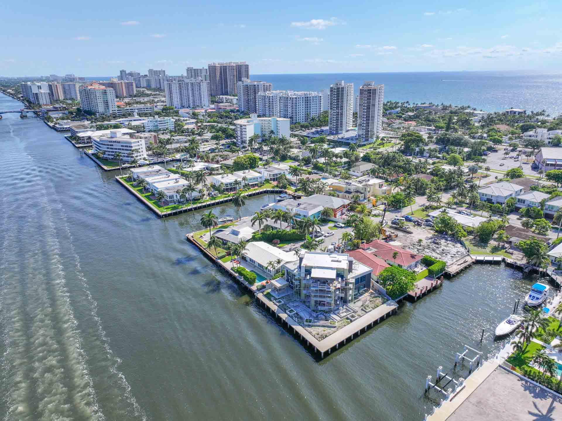 Dolphin Isles Fort Lauderdale waterfront home with private dock, clear view of Atlantic Ocean and beach in background.