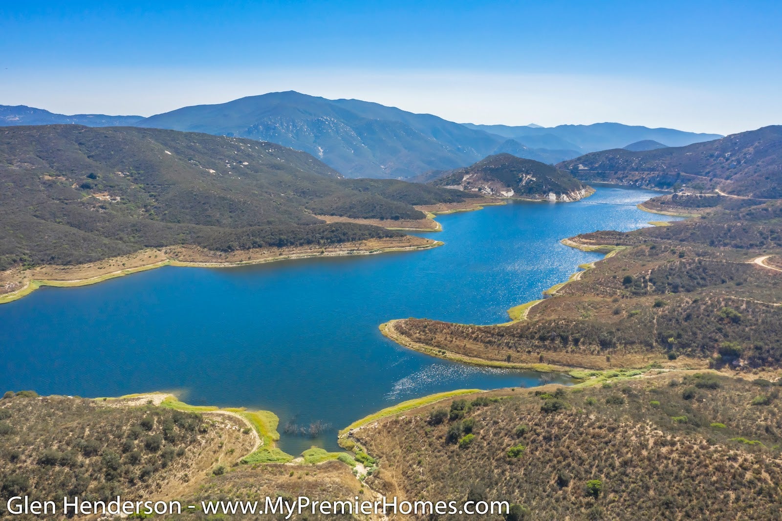 An aerial view of Alpine featuring the sea and mountain range in the distance.