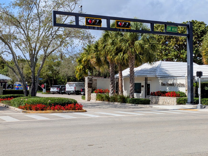 Sea Ranch Lakes gated community street view with mature trees and landscaping