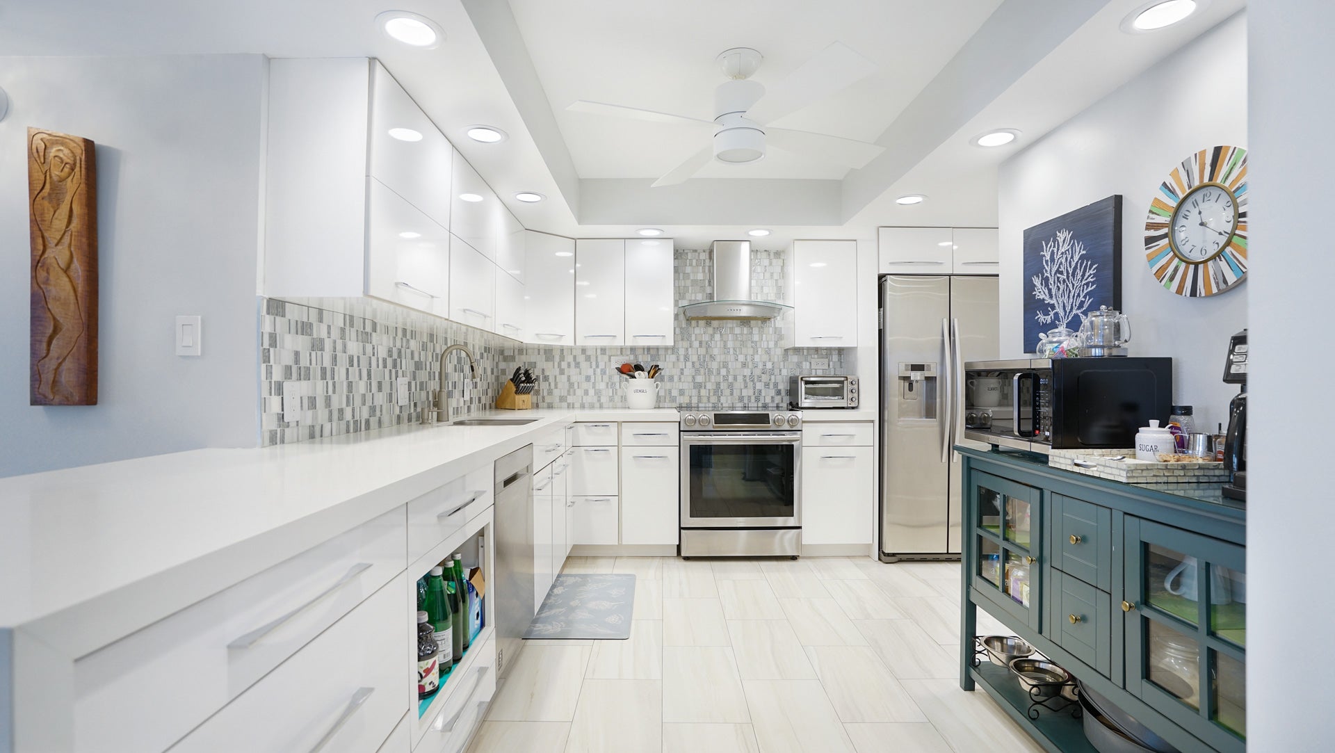 Cook in style in this fully updated, modern white kitchen featuring premium stainless steel appliances, a sleek mosaic tile backsplash, and ample storage space in this highly sought-after Galt Ocean Mile residence. property photo for Cook in style in this fully updated, modern white kitchen featuring premium stainless steel appliances, a sleek mosaic tile backsplash, and ample storage space in this highly sought-after Galt Ocean Mile residence.