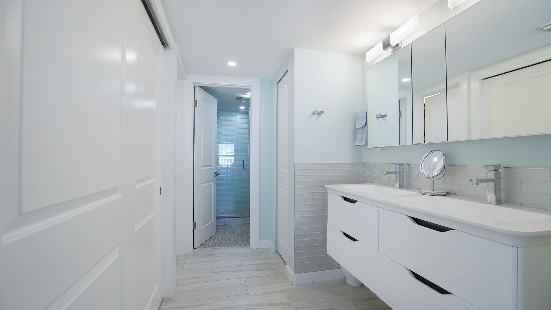 Experience spa-like luxury in this beautifully renovated bathroom, complete with a modern floating double vanity, sleek tile work, and an elegant glass shower. property photo of Experience spa-like luxury in this beautifully renovated bathroom, complete with a modern floating double vanity, sleek tile work, and an elegant glass shower.