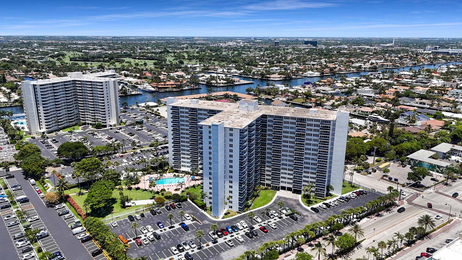 Take in the spectacular aerial perspective of the 17-story Coral Ridge Towers East, perfectly situated in the serene Bermuda Riviera neighborhood of Fort Lauderdale. Showcasing its distinctive architecture against the beautiful backdrop of the winding Int