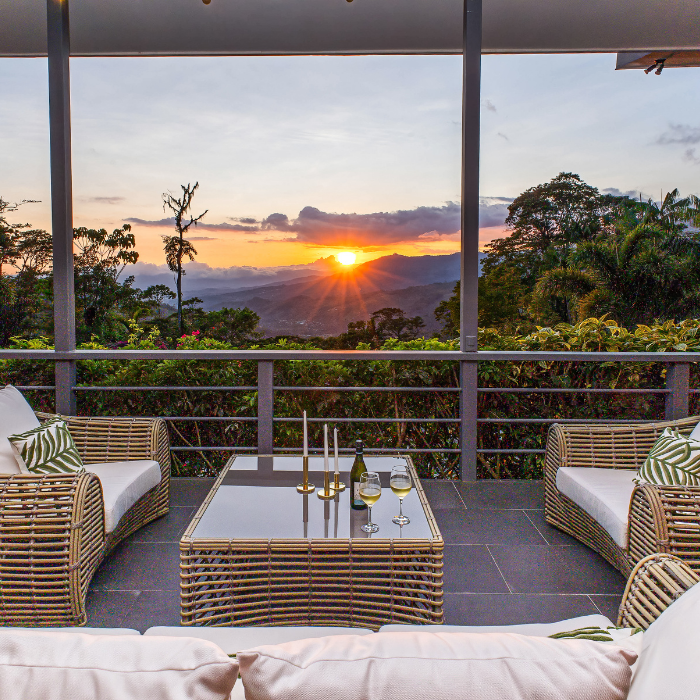 Terrace with rattan furniture and mountain sunset in Pérez Zeledón