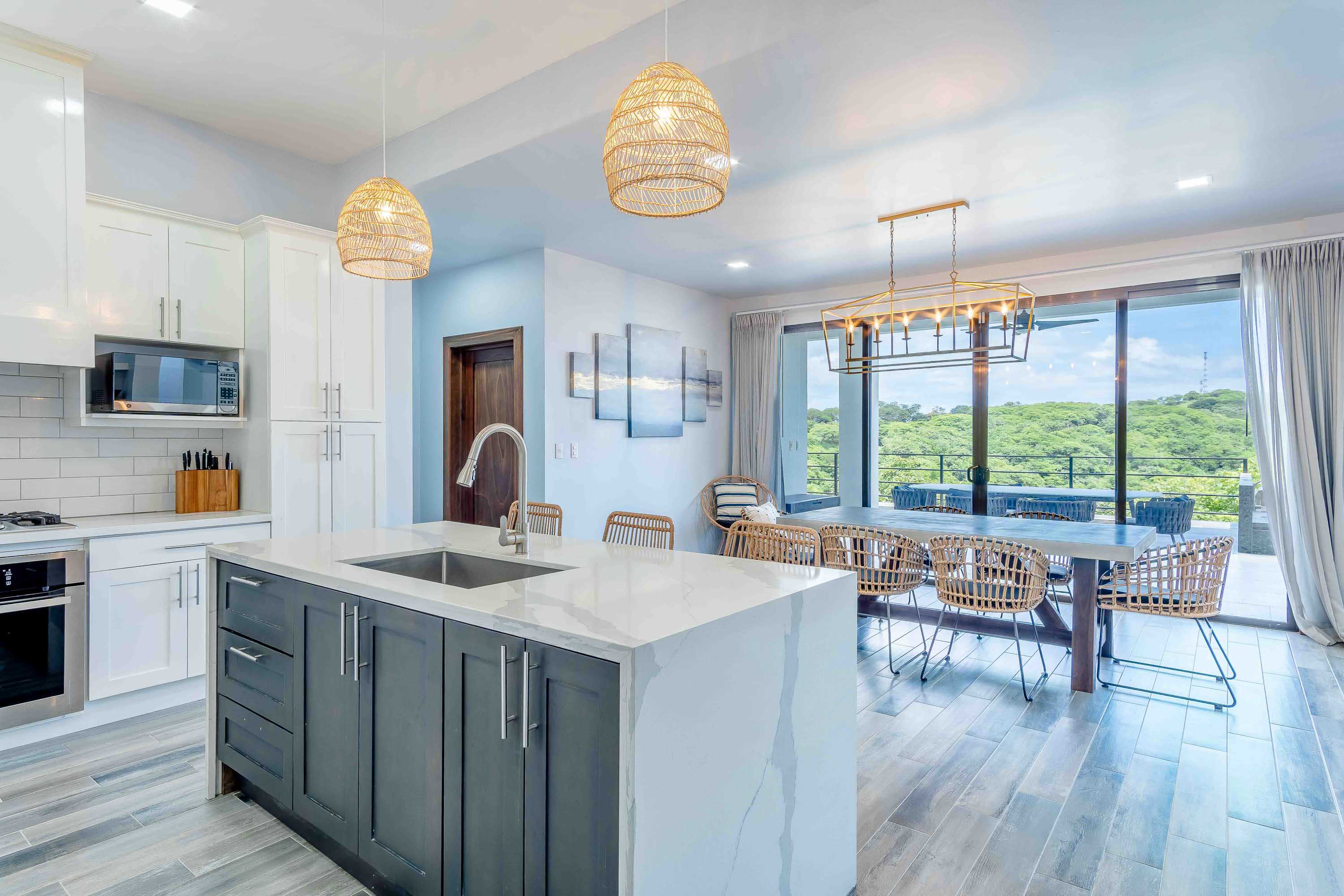 Contemporary kitchen with marble island and elegant dining area in a luxury Papagayo, Costa Rica home.