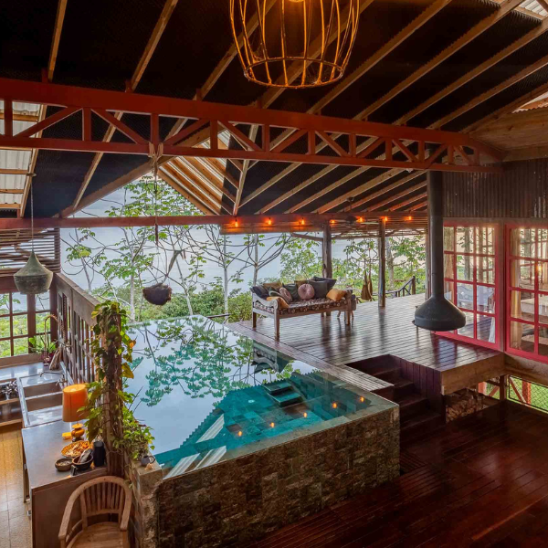 alt:Luxury home interior with indoor plunge pool, wood deck, and ocean view