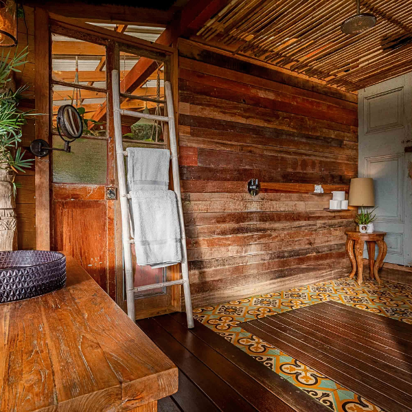 Rustic bathroom with wood walls, patterned tile floor, and outdoor shower area