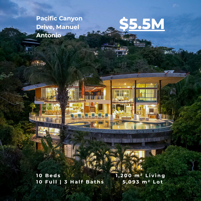 Multi-level luxury villa at dusk with large glass walls, infinity pool, and jungle surroundings.