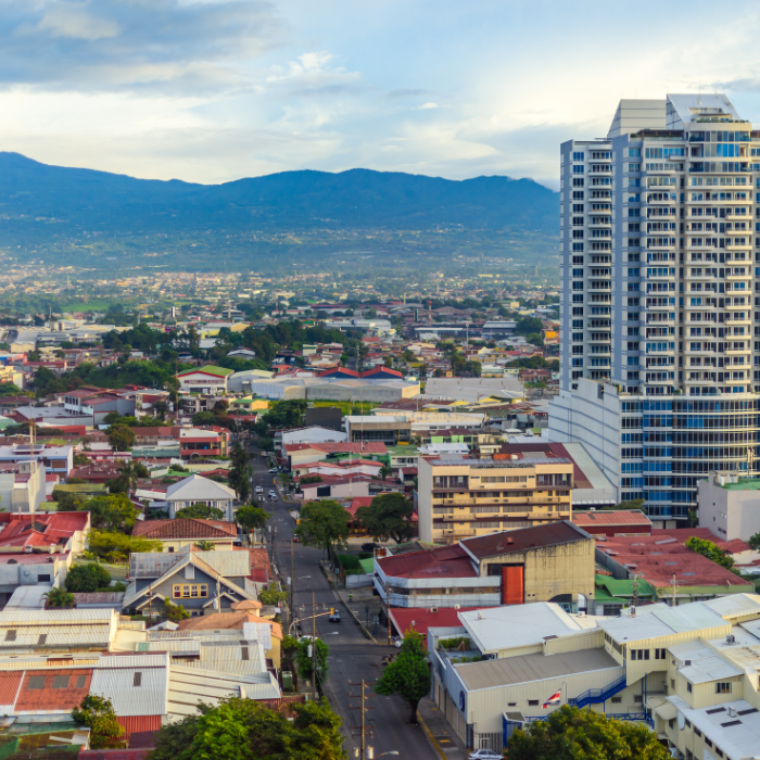 Aerial view of San José, Costa Rica with residential buildings and mountains in the background.