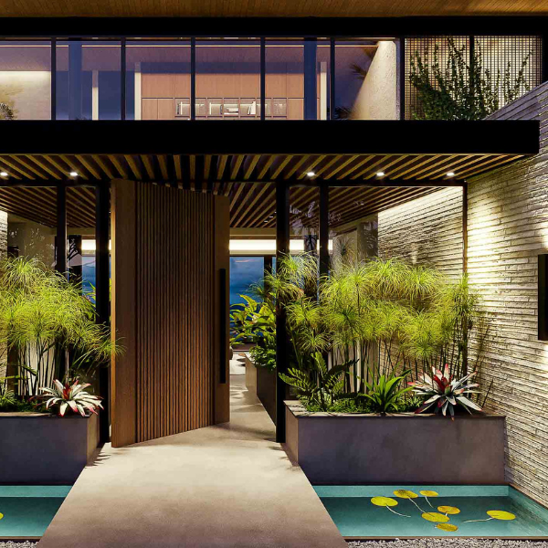 Entrance with wooden pivot door and tropical garden in a Guanacaste villa.