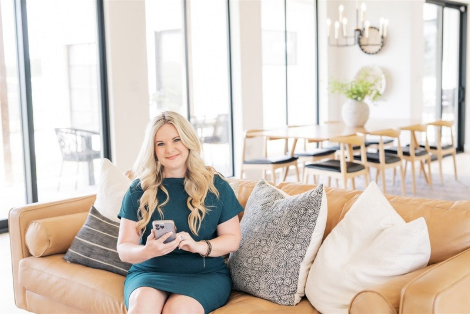 Amanda Pullen, REALTOR, sitting on a couch in a bright living room